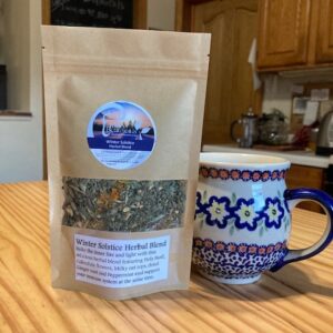 a bag of winter Solstice Herbal Blend tea on a kitchen table next to a mug