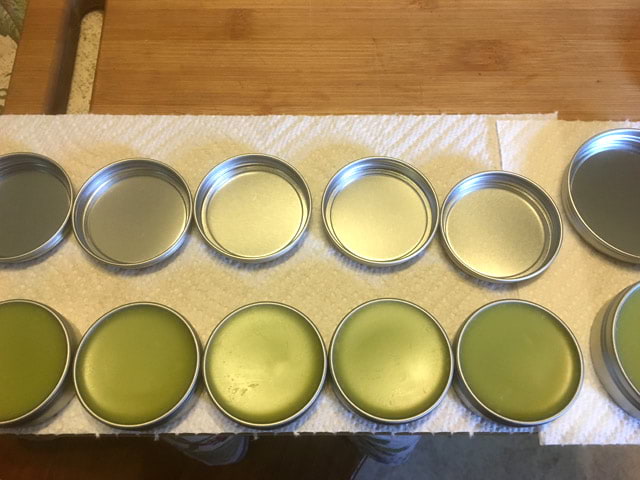 comfrey salves in round metal containers